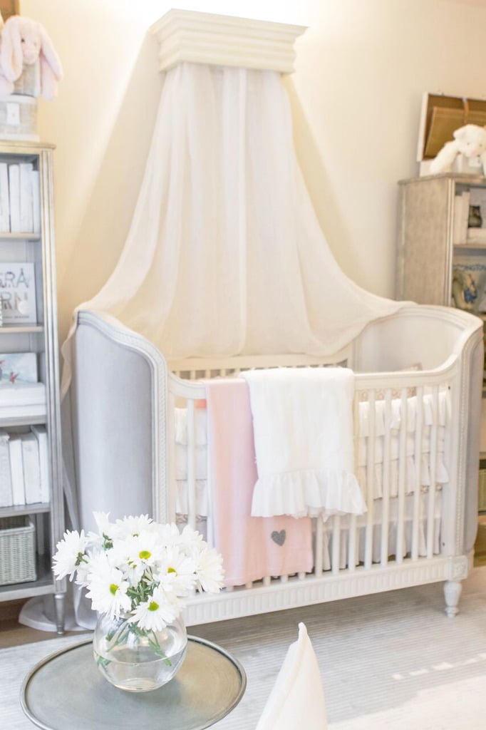 A wood canopy bed crown ($329) lends drama to the tastefully upholstered crib ($1,449).