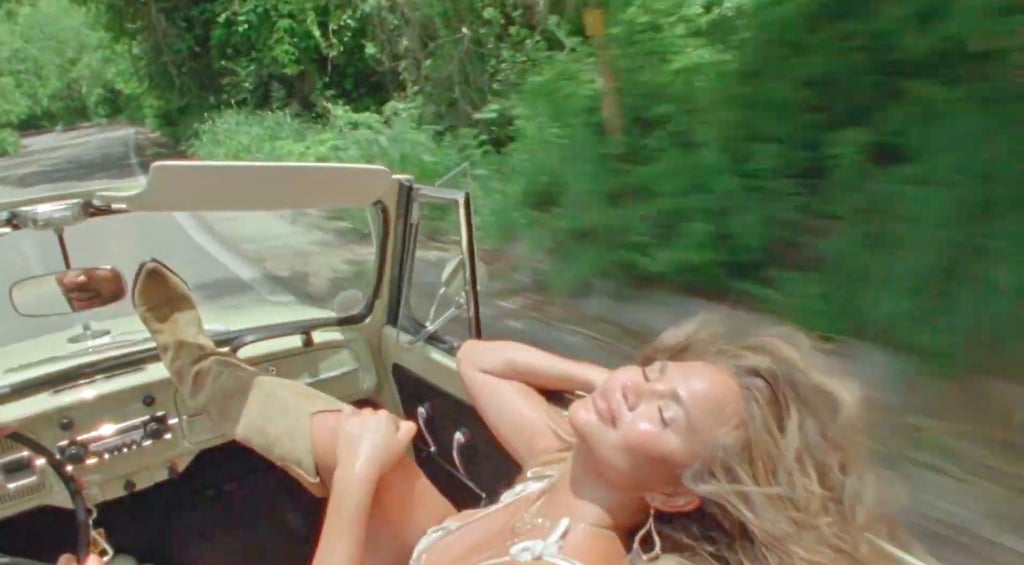 Chrissy Teigen Reveals Pregnancy in a White Dress in "Wild"