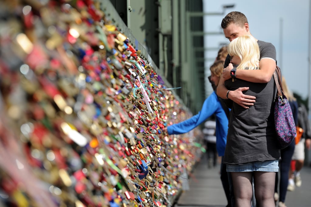 A Couple Embraced After Affixing Their Lock To The Bridge