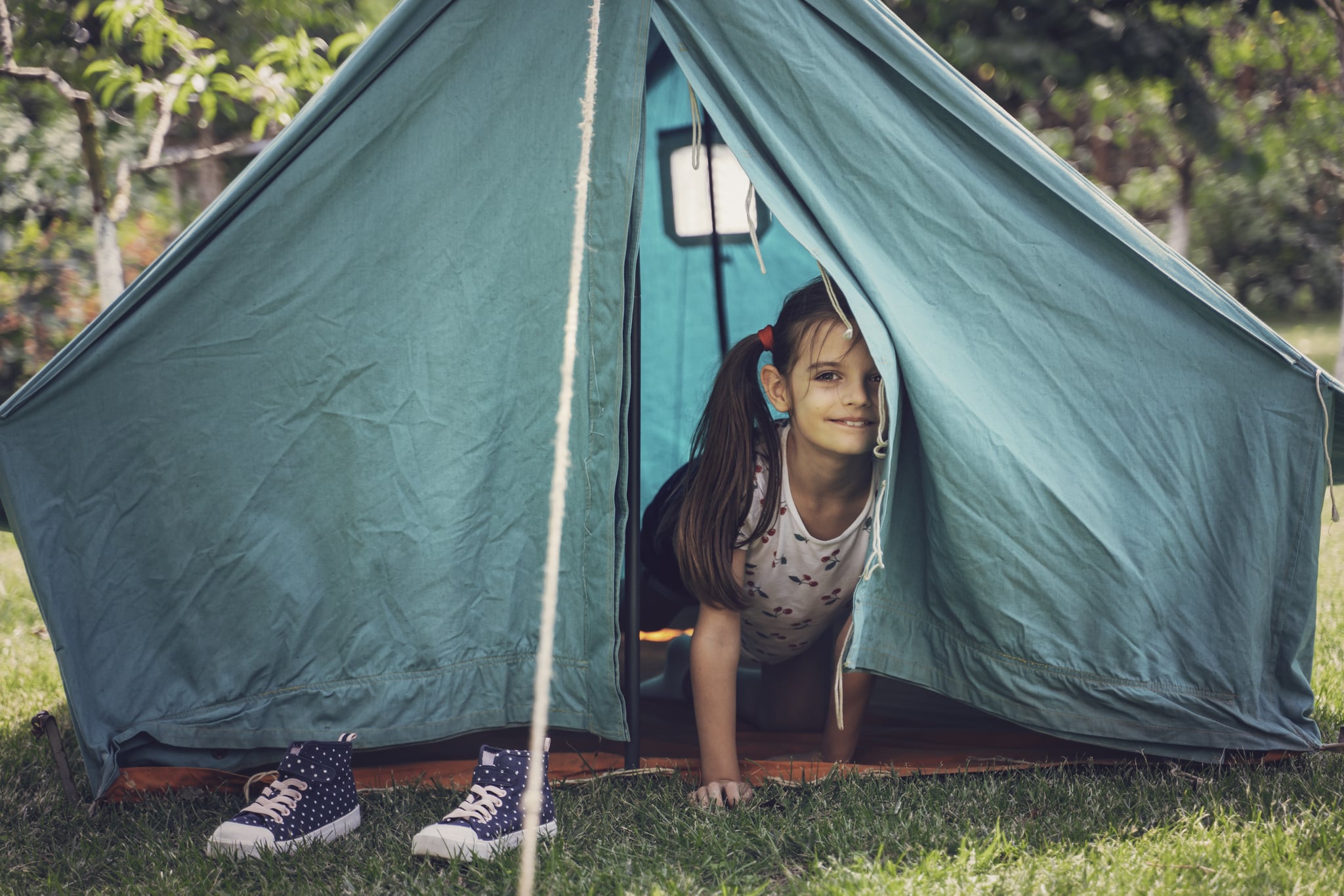 Cute girl playing in tent. Garden party. Summer fun. Child.