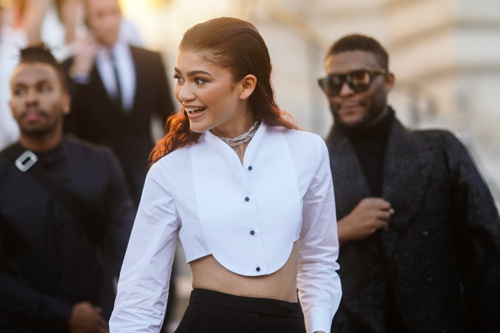 Zendaya abided by the expression "dress for the job you want" when she showed up to Paris Haute Couture Fashion Week looking like a boss. A week after appearing at the Spider Man: Far From Home premiere in a sequined Armani Privé gown reminiscent of the superhero's suit, the actress attended the fashion house's runway show wearing a custom suit, also by Armani. 
She wasn't wearing just any suit, however: this one consisted of perfectly tailored high-waisted trousers and, essentially, a cropped tuxedo shirt. Styled by Law Roach, Zendaya complemented the sexiest suit we've ever seen with classic Christian Louboutin pumps and diamonds by Messika Paris. See photos of Zendaya's daring menswear-inspired outfit ahead, and start placing your bets on how soon it'll be until we're all wearing cropped tuxedo shirts.

    Related:

            
            
                                    
                            

            Couture Fashion Week Street Style Is Surprisingly Relatable