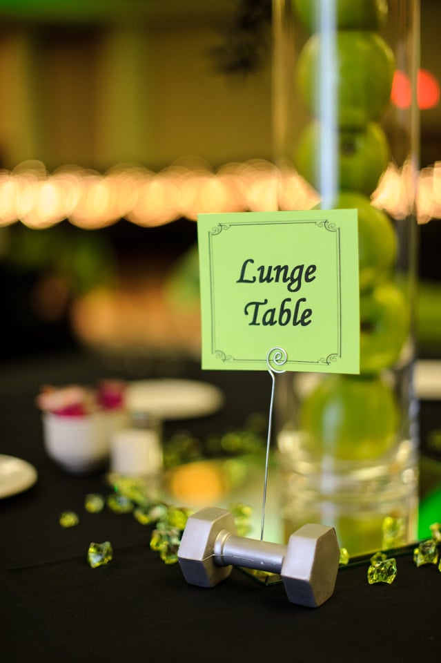 Small details made a big impression on wedding guests. Tables were decorated with flowers, fresh apples, and plenty of dumbbells to go around! To stay in line with the fit theme, each table was named after a different exercise.