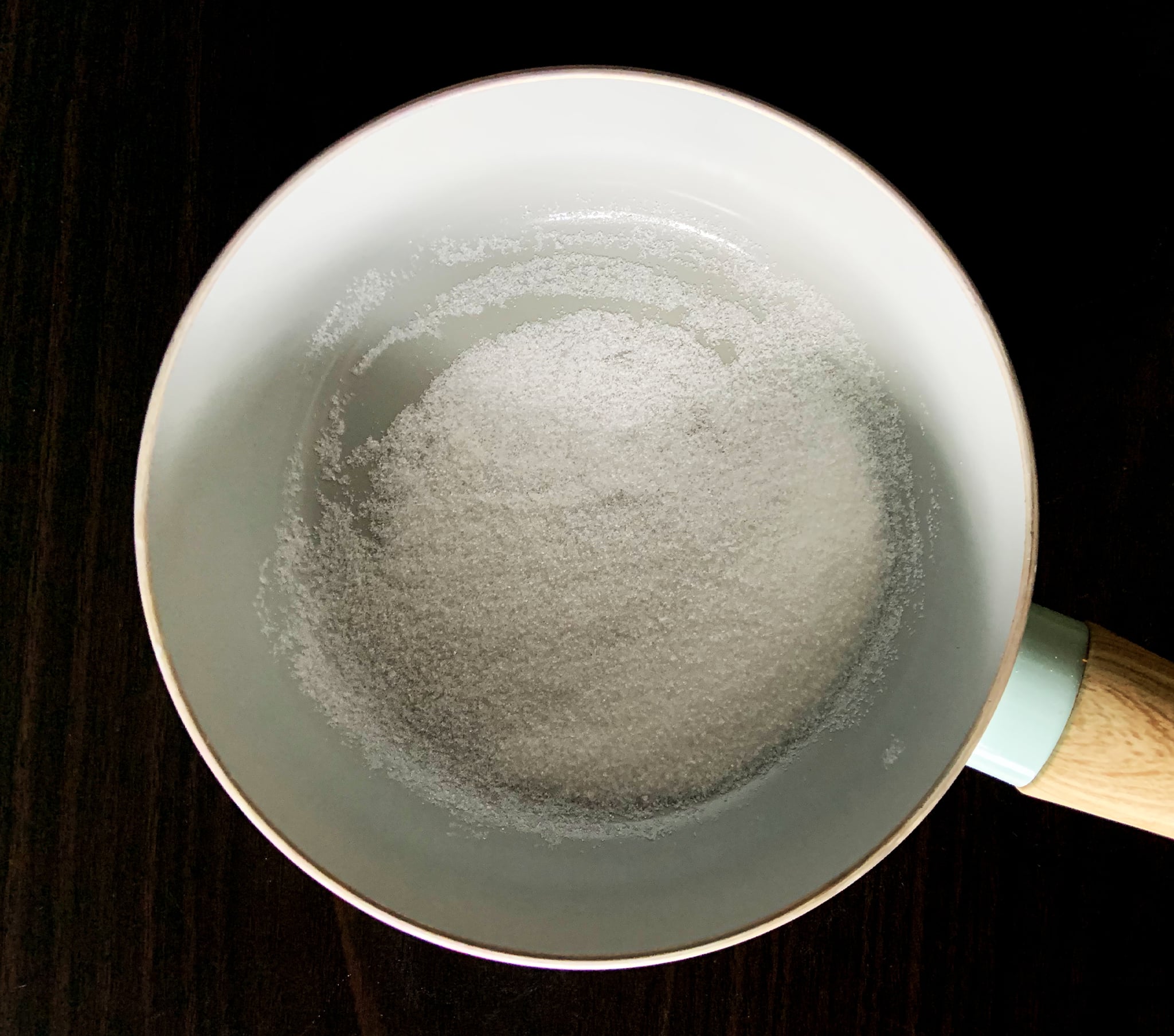 Saucepan with two tablespoons of sugar