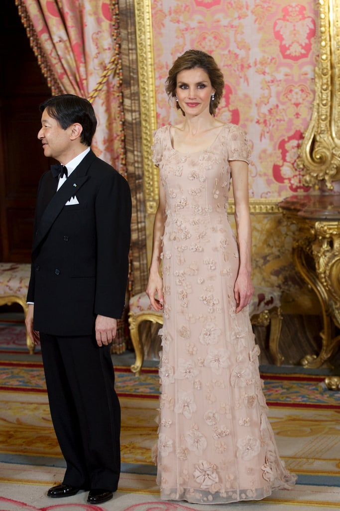 Wearing a Buff Short-Sleeved Gown With Floral Embellishments