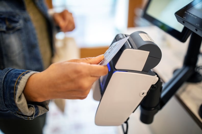 Midsection of woman using credit card for contactless payment at checkout at zero waste store