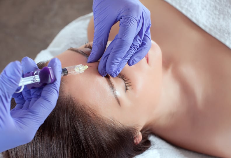 There are a woman and a cosmetologist, the woman is lying and the doctor is making the facial injections procedure for tightening and smoothing wrinkles in a beauty salon.Cosmetology skin care.
