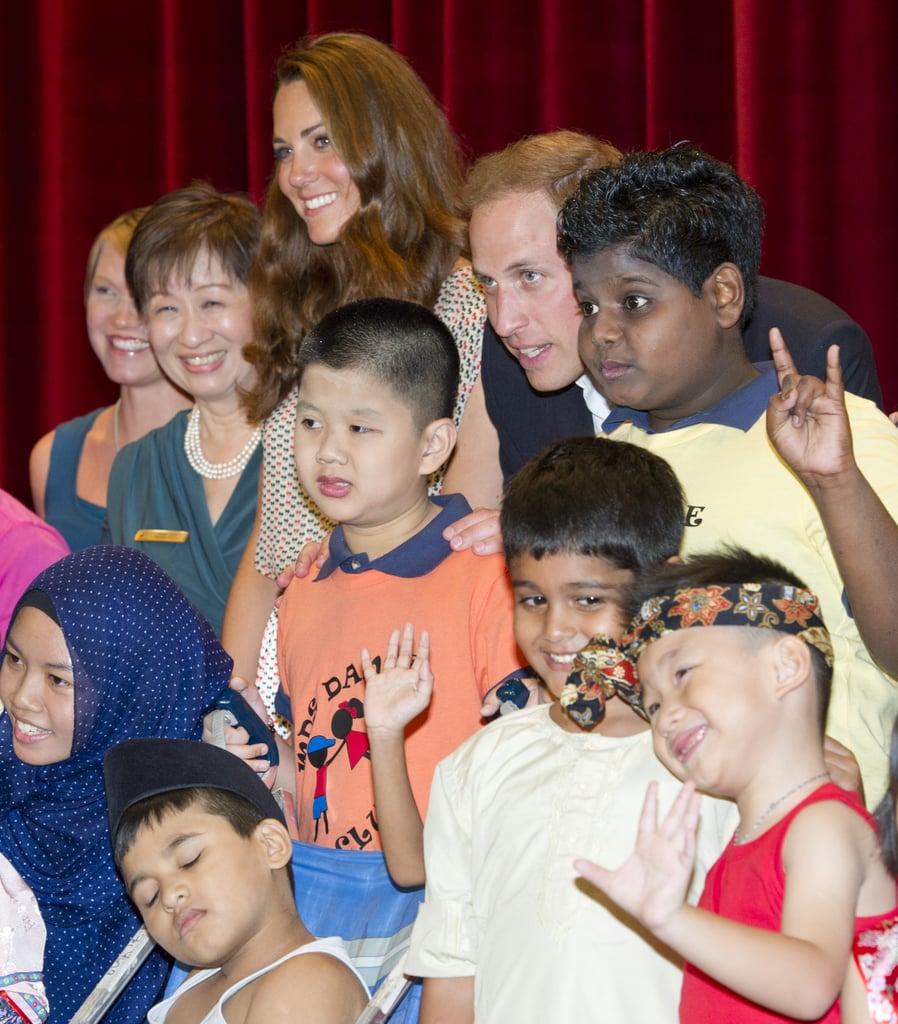 Kate and Will got together for a group photo with cute kids and their teachers during a visit to Singapore's Rainbow Center in September 2012.
