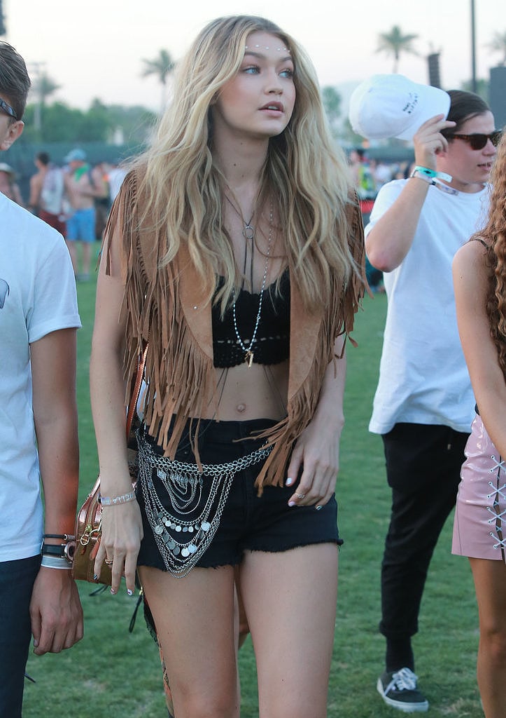 Amping up her festival look, the star layered an Asos Fringe Suede Cape ($91) over her crop top and shorts.