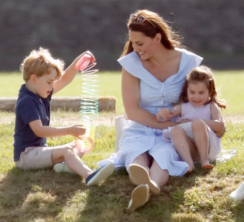 Kate smiled wide as George stretched out a Slinky, while tightly gripping Charlotte. This mama just loves her little ones!