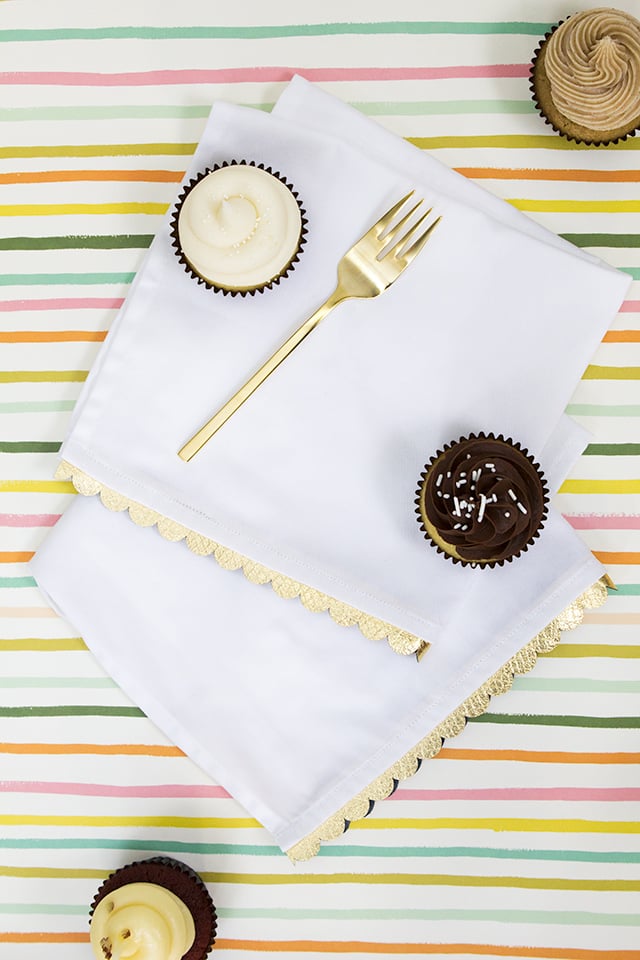 If stamping designs on your napkins isn't your style, you can go for a more year-round look, adding DIY scalloped edges to plain white napkins for a holiday look that shines.
