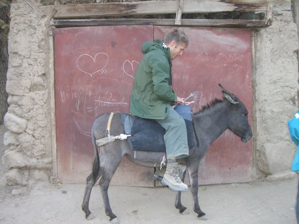Here, he tries out some local transportation in the country: a donkey.
