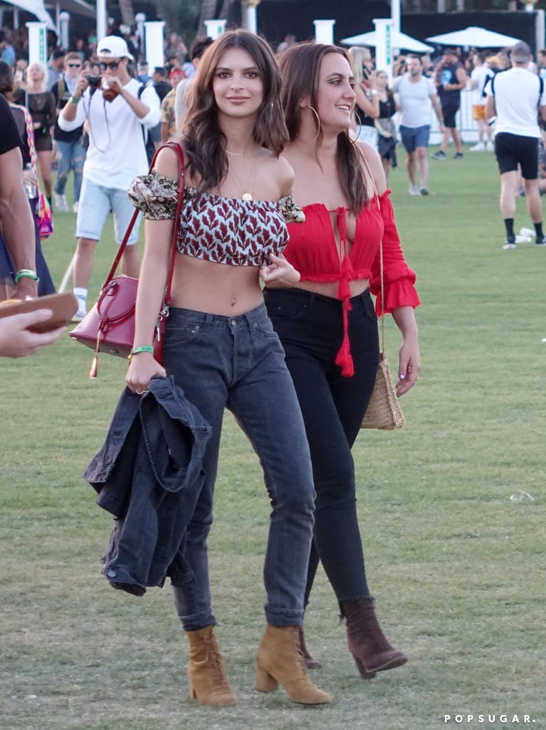 Emily Ratajkowski wearing a crop top, high-waist jeans, Forever 21 denim jacket, Taylor Morris sunglasses, and suede boots at the festival. 