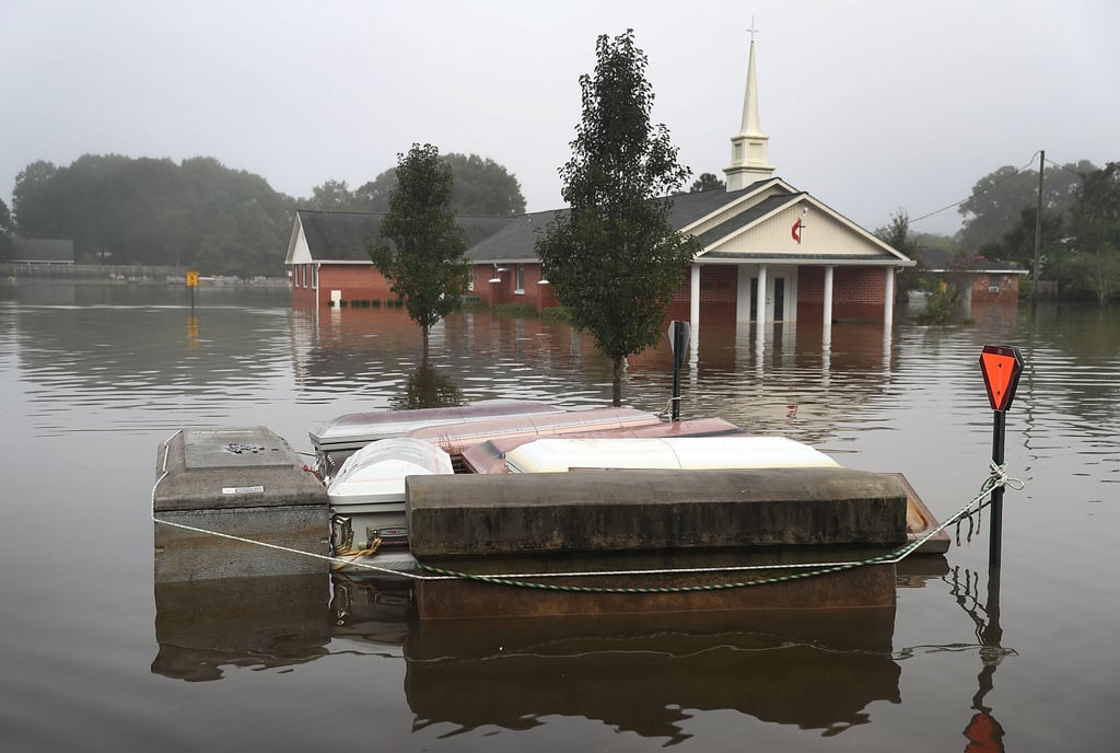 A casket floats in the water near a cemetery.