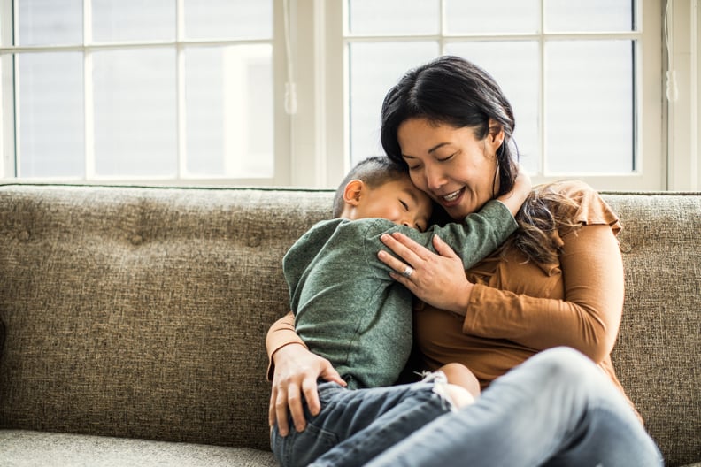 Mother hugging son on couch