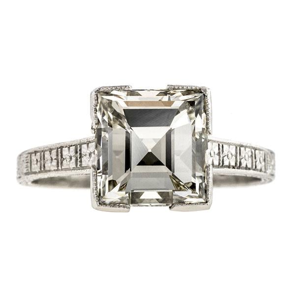 "Our Art Deco Square Step Cut Diamond Ring keeps the focus on the beautiful, crisp centre stone. It has minimal millegrained detailing on the mounting and hand-engraved details on the shank to balance out the design."