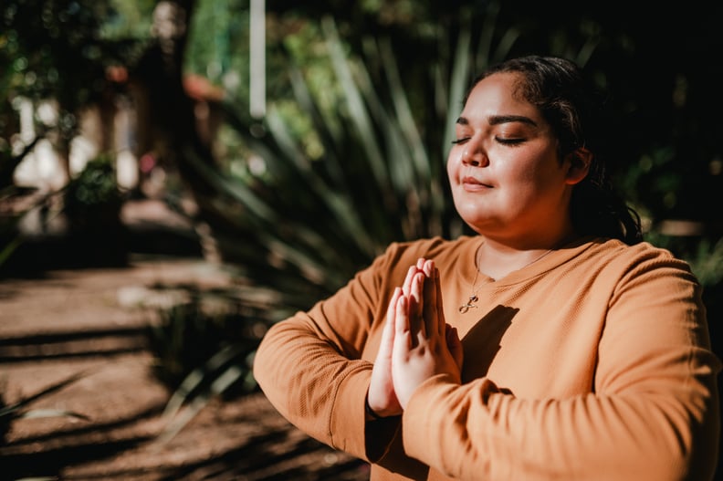 Enjoying the sunny day. Woman meditating