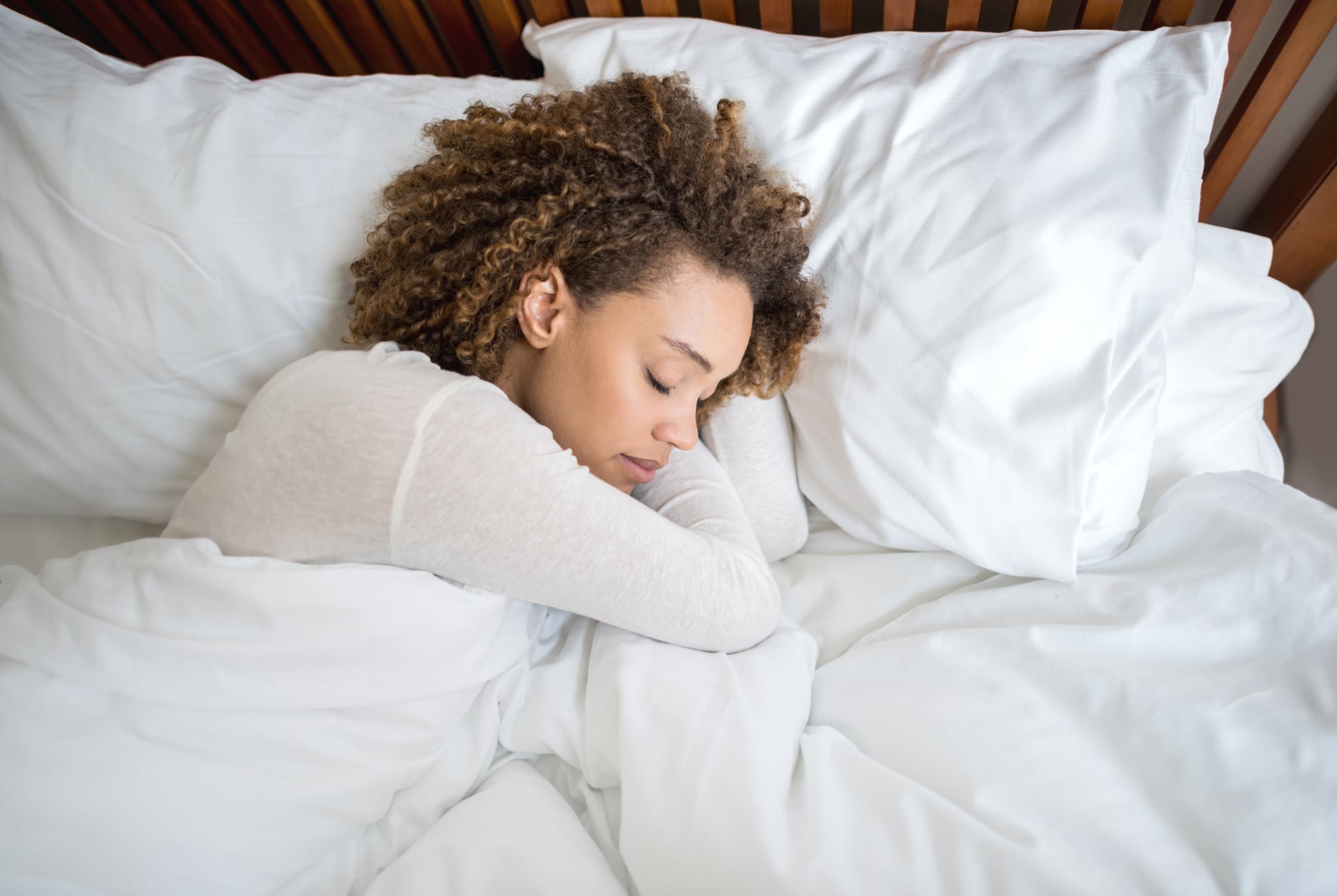 Tired African American woman sleeping in bed at home