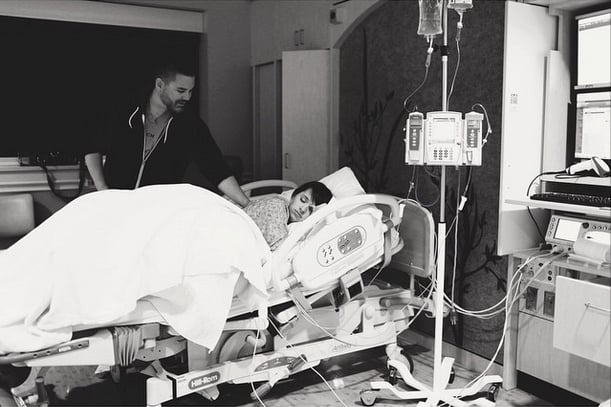 Mom is finally feeling the contractions and is becoming less comfortable. The conversation has subsided as she rests.
