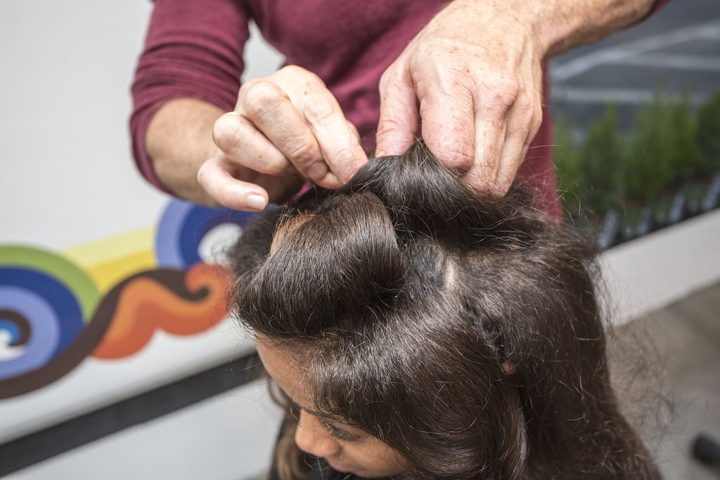 "One thing about textured hair is you can make shapes to get a seamless look," Dickey explained. Starting in the front, take random sections and roll hair around two fingers to form a barrel shape. Secure with bobby pins. 
Continue rolling sections (the majority of the curls should be toward the front of the face and bit off center).