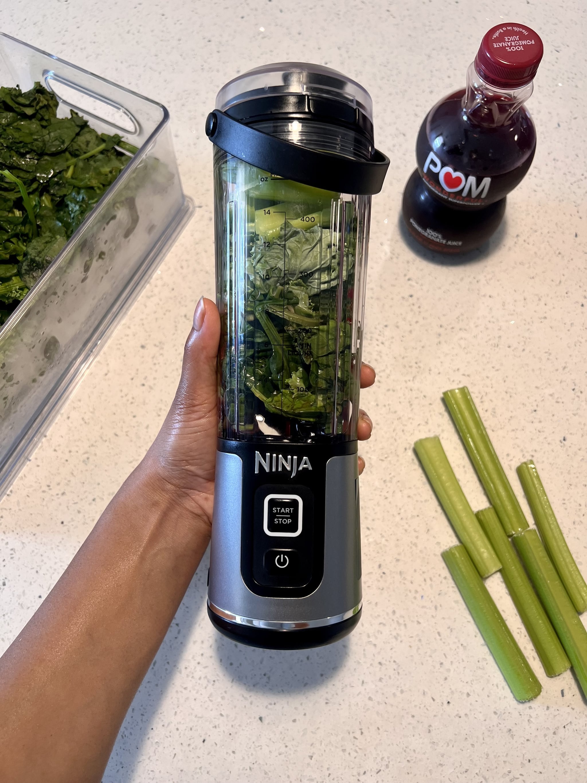 The Ninja Blast Portable Blender with leafy greens, celery, and ice inside.