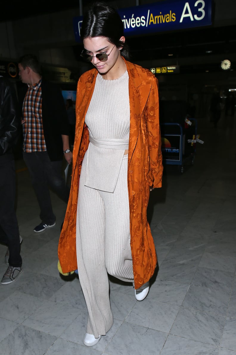 Kendall Walked Through the Airport on Wednesday Wearing an Orange Duster Over Her Beige Outfit