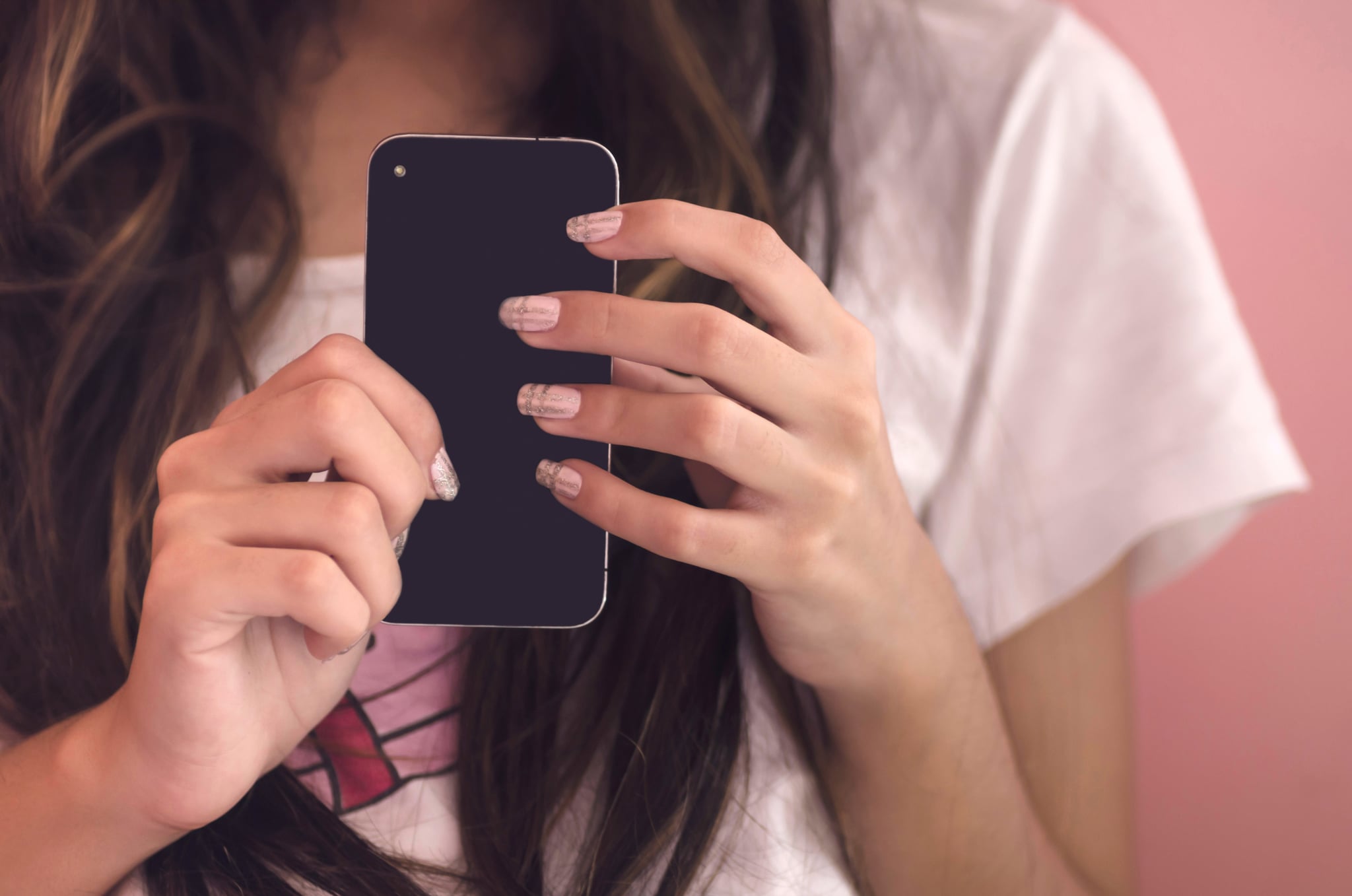 Young woman holding her smart phone, close-up
