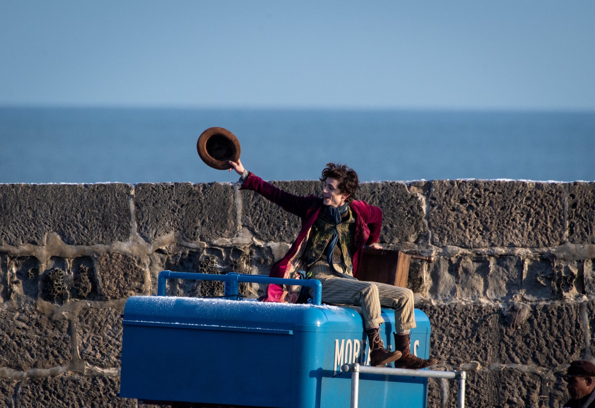 LYME REGIS, ENGLAND - OCTOBER 12: Timothée Chalamet is seen as Willy Wonka leaving the ship on the top of a van during filming for the Warner Bros and the Roald Dahl Story Company's upcoming movie 'Wonka' on October 12, 2021, in Lyme Regis, England. This film will focus on the young Willy Wonka on his earliest adventure and how he met the Oompa-Loompas. (Photo by Finnbarr Webster/Getty Images)