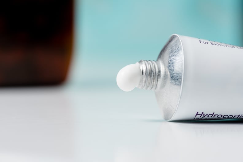 A tube of hydrocortisone cream on a domestic bathroom top with a blue background.