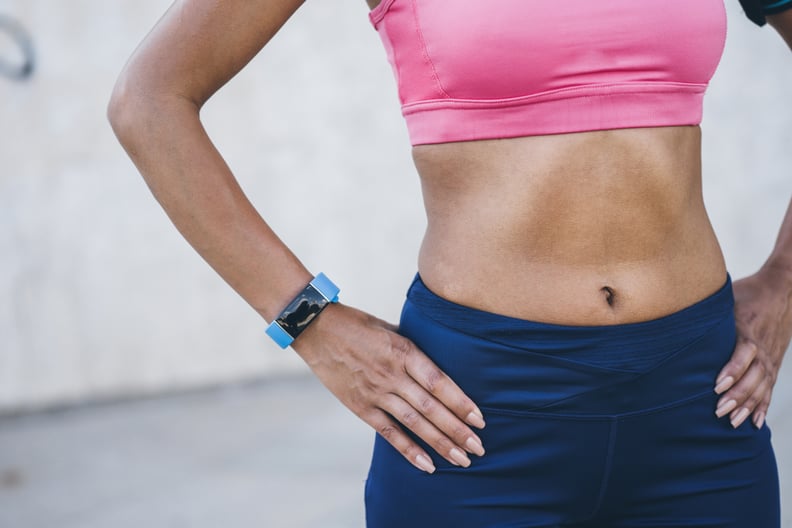 Female athlete with her hands on hips wearing smart watch