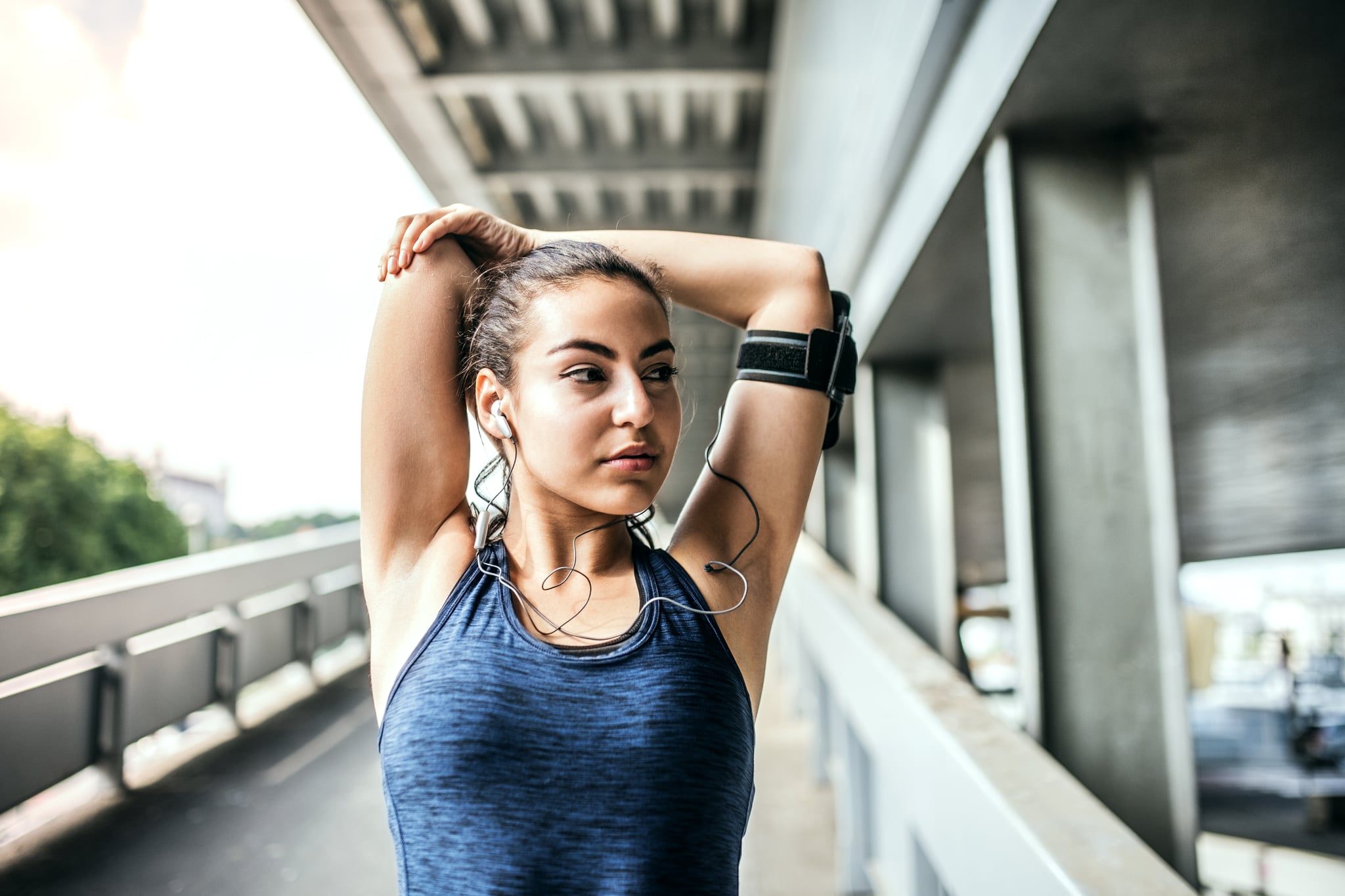 An active girl under a concrete bridge resting after doing sport. Copy space.