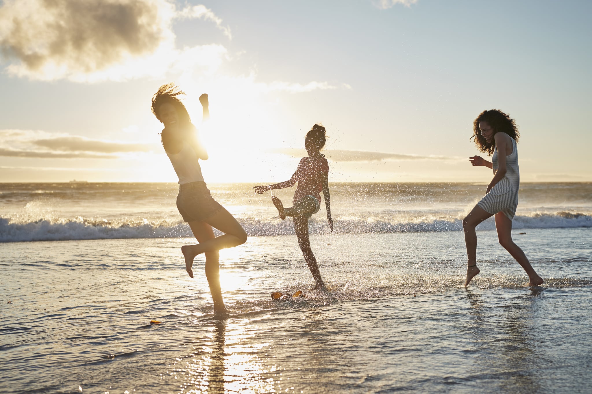 Young women hanging out at the beach, at sunset