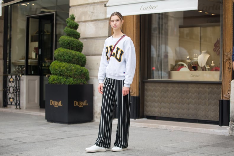 College-Sweatshirt Outfit: Wear It With Striped Palazzo Pants and Sneakers