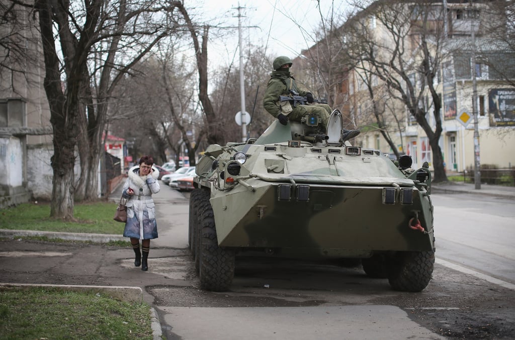 Signs of a possible conflict between pro-Russian and Ukrainian forces came after Putin signed a treaty to annex Crimea. On Tuesday, Russian military personnel surrounded a Ukrainian military base in Simferopol, and when masked gunmen descended on the base, a member of the Ukrainian military was killed. The next day, nearly 300 armed pro-Russian supporters took over a Ukrainian navy headquarters in Sevastopol, replacing Ukrainian flags with Russian flags.