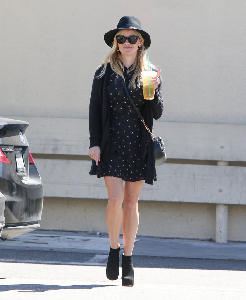 We love how Reese topped off her printed dress, black cardigan, and ankle booties with a wide-brimmed hat.