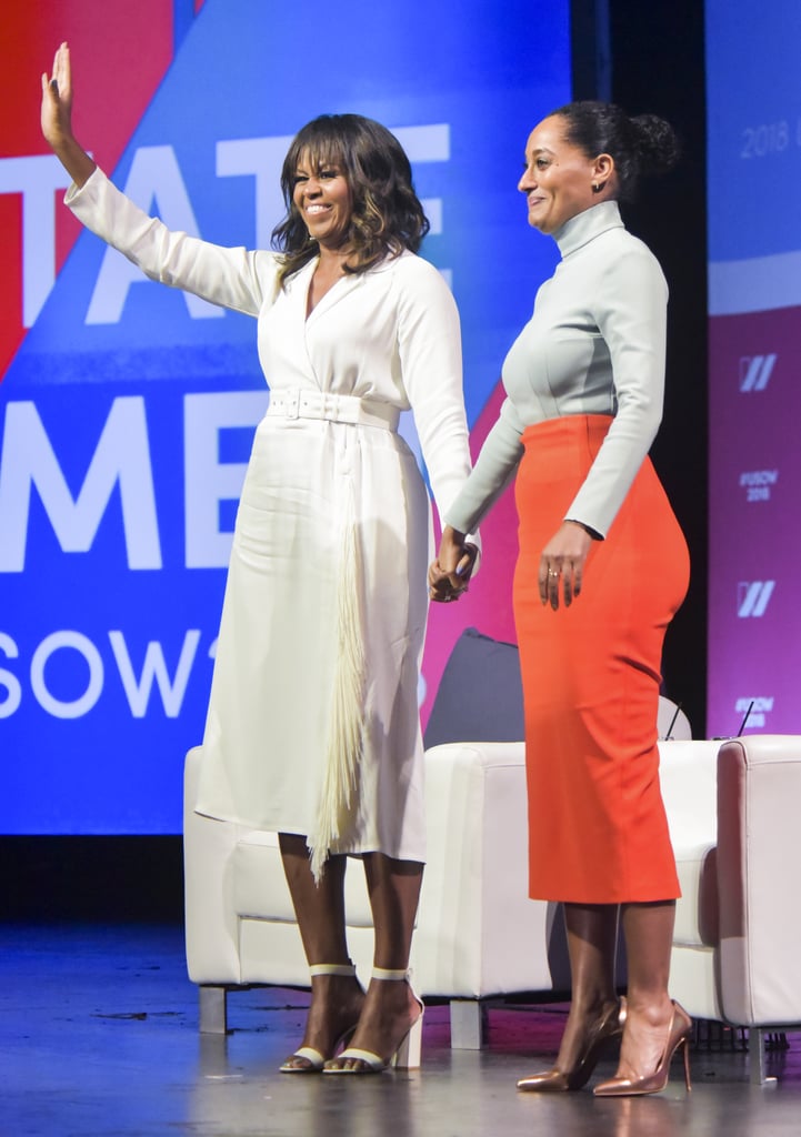 Michelle wearing a white fringe Rachel Comey wrap dress while talking to Tracee Ellis Ross at the United State of Women Summit in Los Angeles.