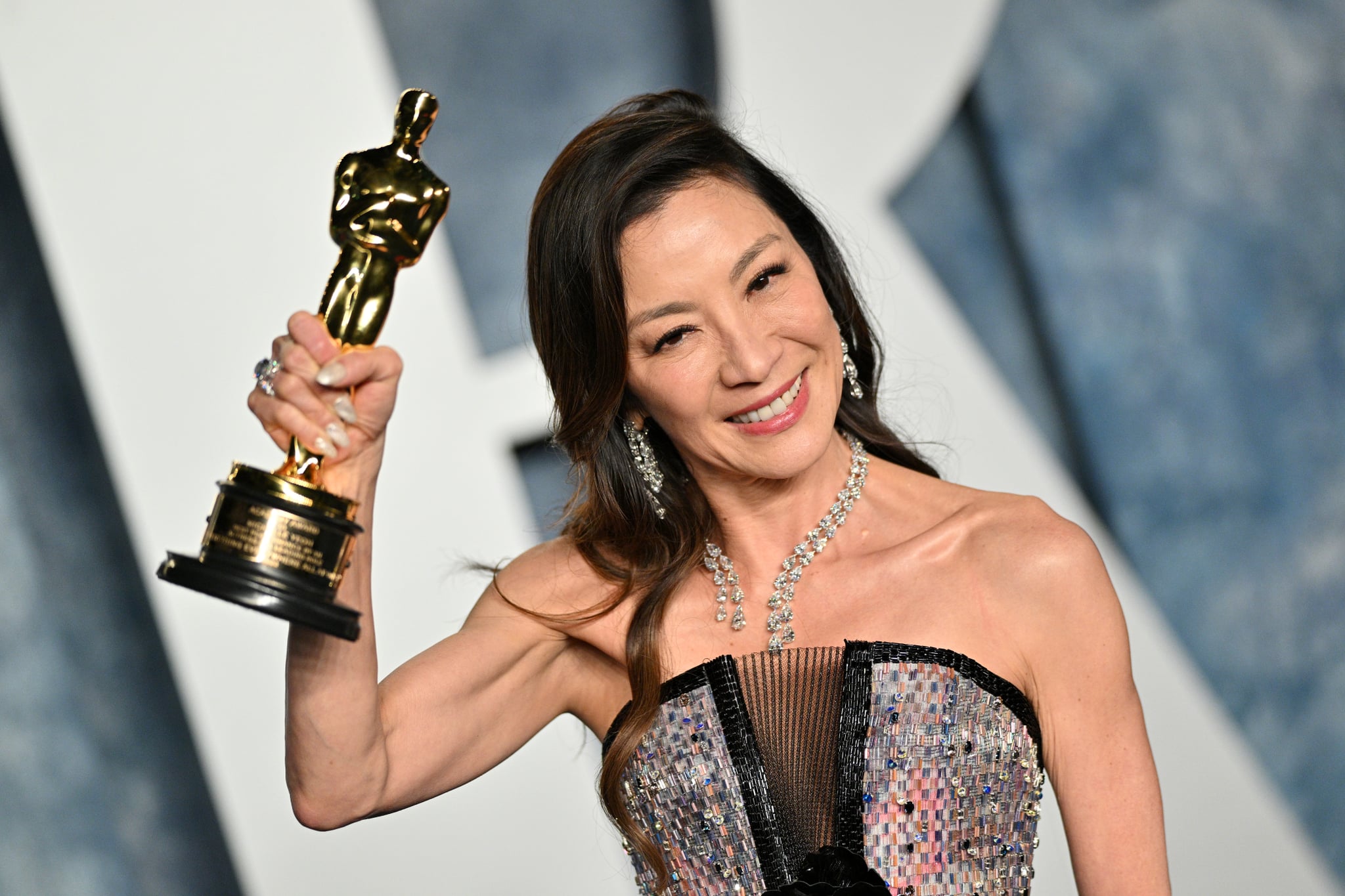 Michelle Yeoh at 2023 Vanity Fair Oscar Party with Oscar trophy