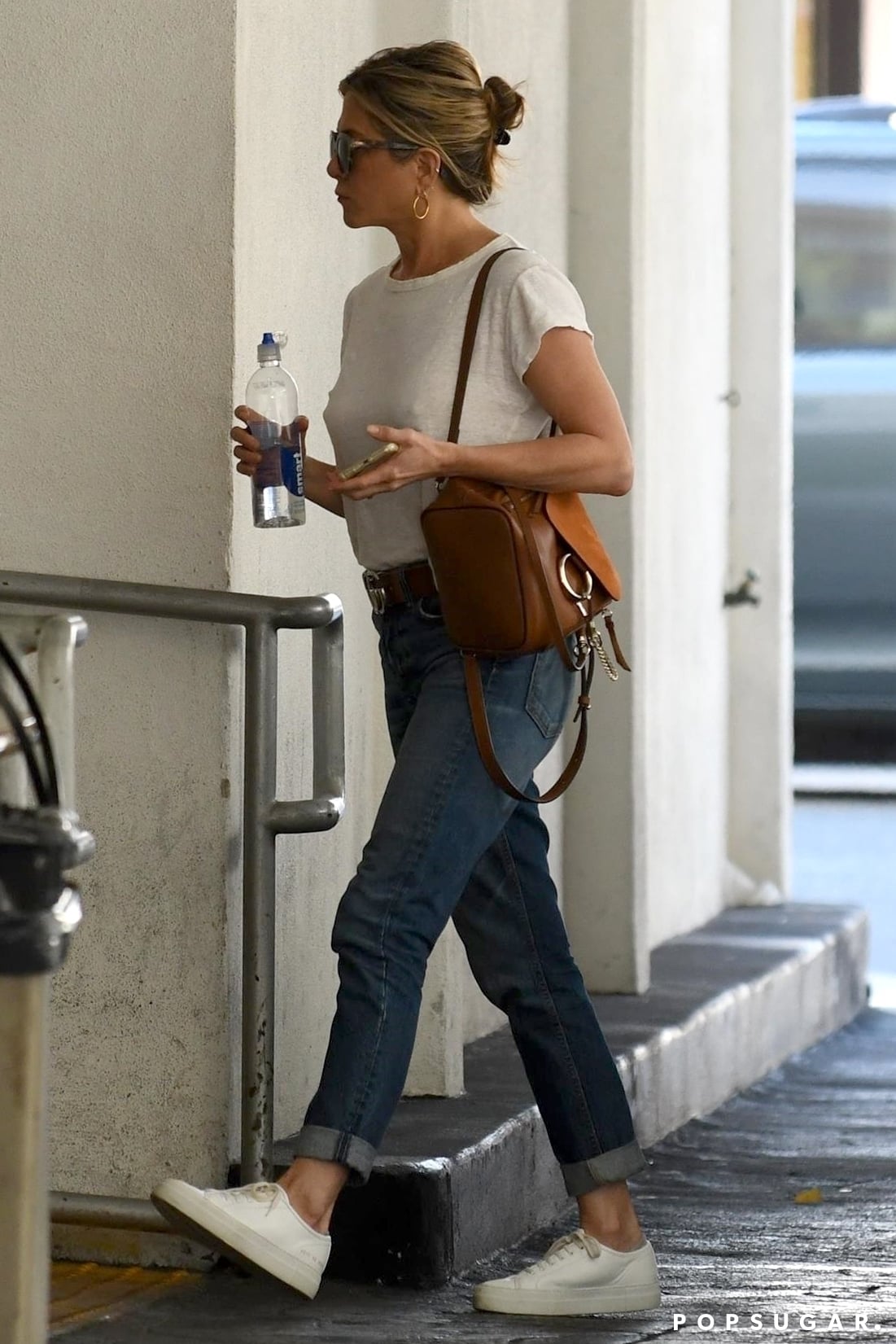 Jennifer Aniston in pink top, blue leggings and brown bucket bag in LA on  July 26 ~ I want her style - What celebrities wore and where to buy it.  Celebrity Style