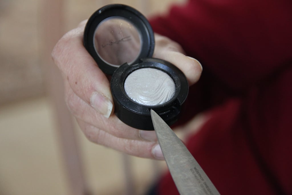 Take your knife and place it at the seam at the closure of the compact. Wiggle your knife around until the small plastic casing and shadow pan pop out of the larger packaging.