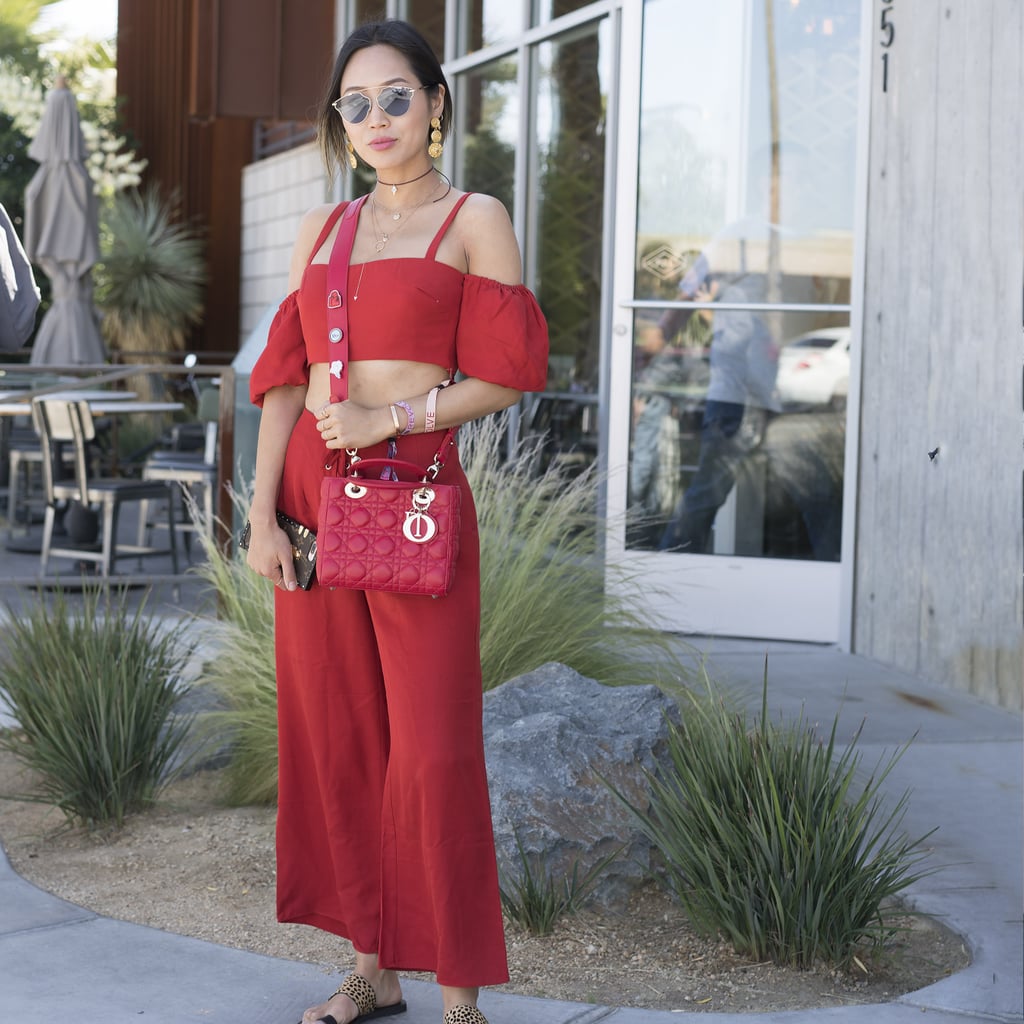 Aimee Song wearing a Dior bag and red coordinate set at the Revolve pool party. 