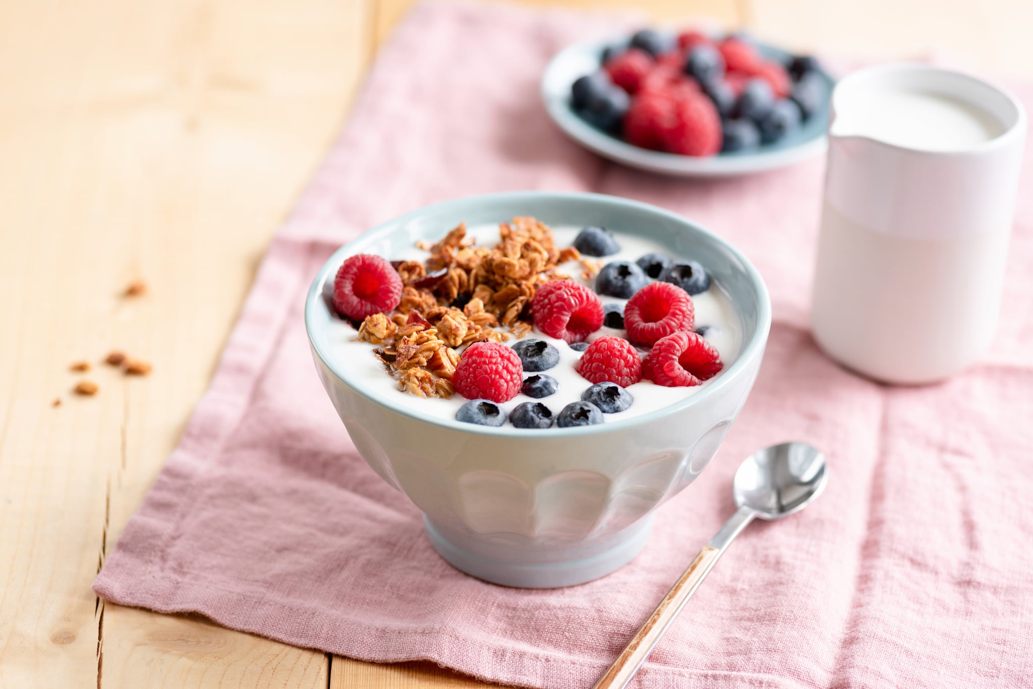 Yogurt with granola and berries in bowl on wooden table. Healthy eating, dieting, weight loss concept