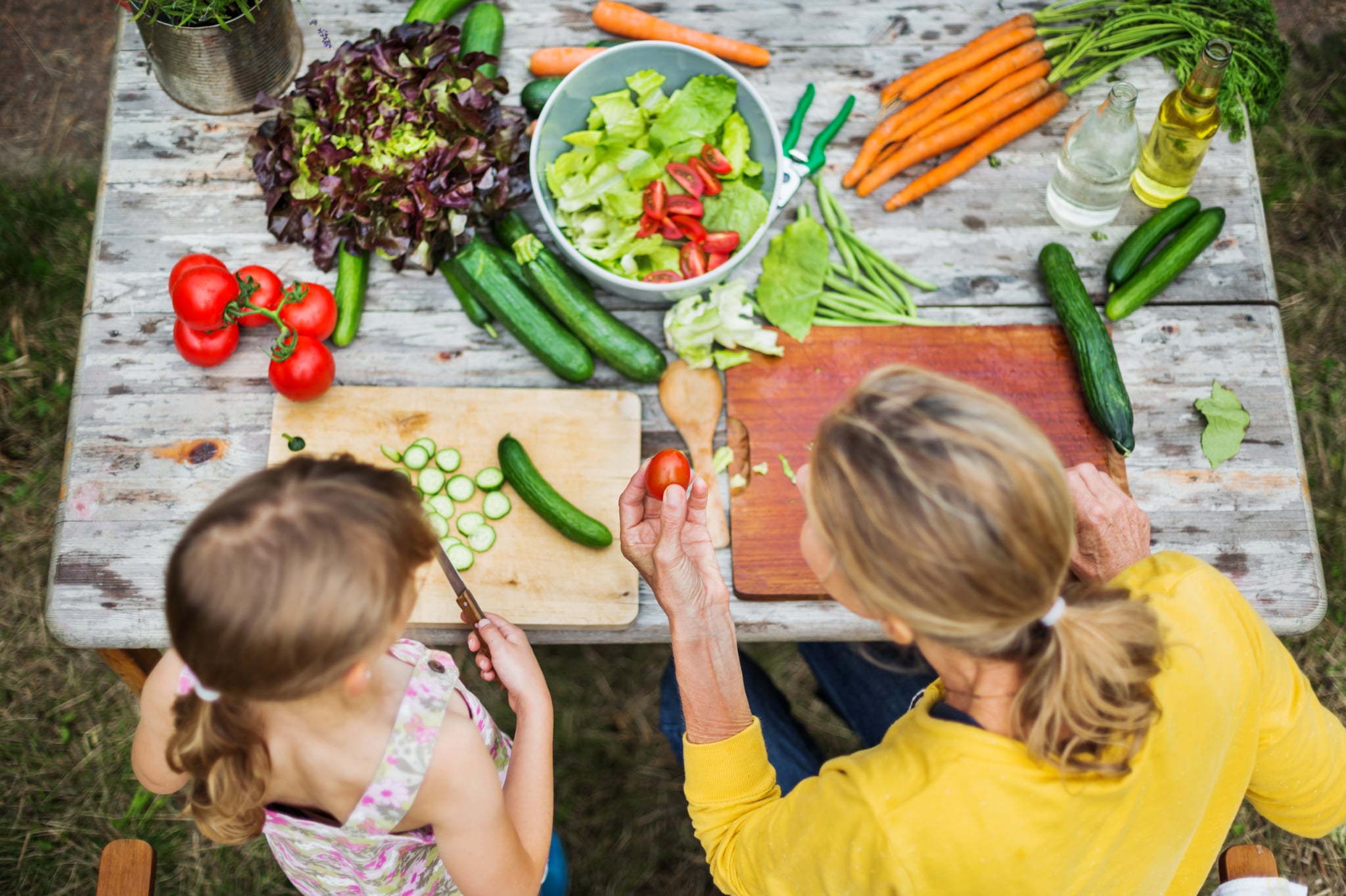 Mother And Daughter Preparing Fresh Salad in a garden