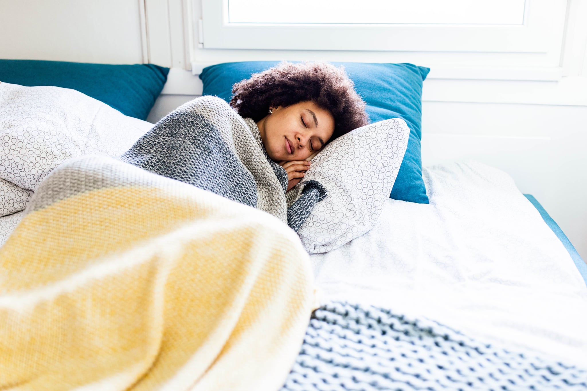 Young black woman sleeping in a bed.