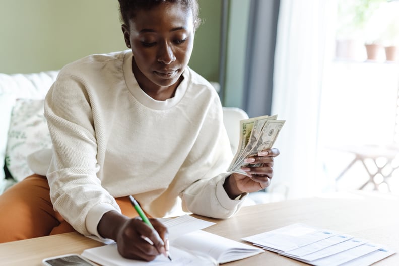 woman holding cash and putting money in envelopes
