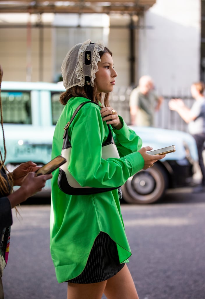 An electric green button-down is an unexpected counter to a lace headpiece.