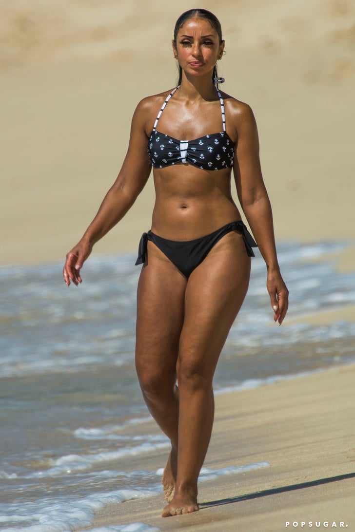 Met slank lichaam en Zwart haartype zonder BH(cup)  op het strand in bikini
