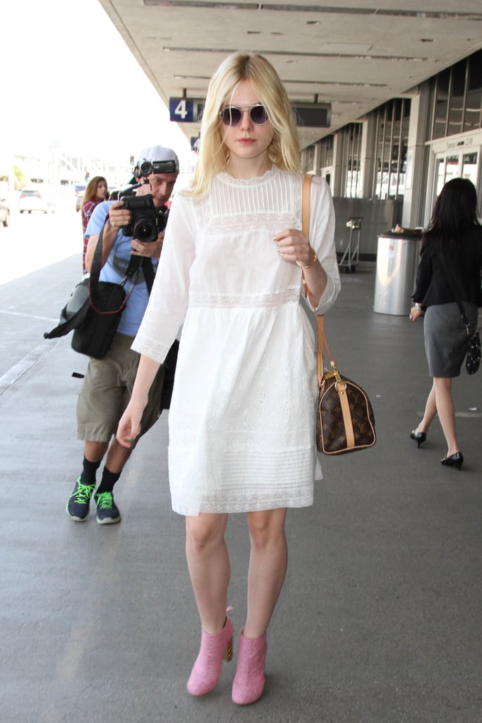 A loose white dress and pink booties really made Elle Fanning's airport outfit stand out in the crowd.