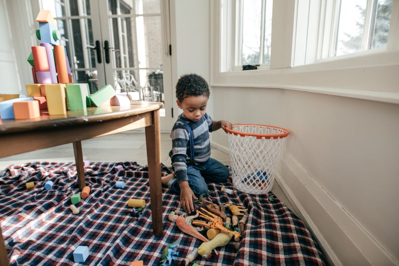 Child picking up his toys.