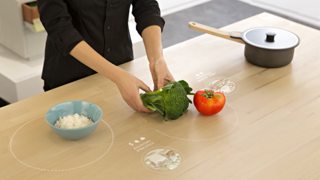 What doesn't the Table for Living do? It lets you heat food directly on the table, suggests what to cook based on your leftovers, tells you how to cut certain ingredients, browses recipes, and cooks with different pans and temperatures.