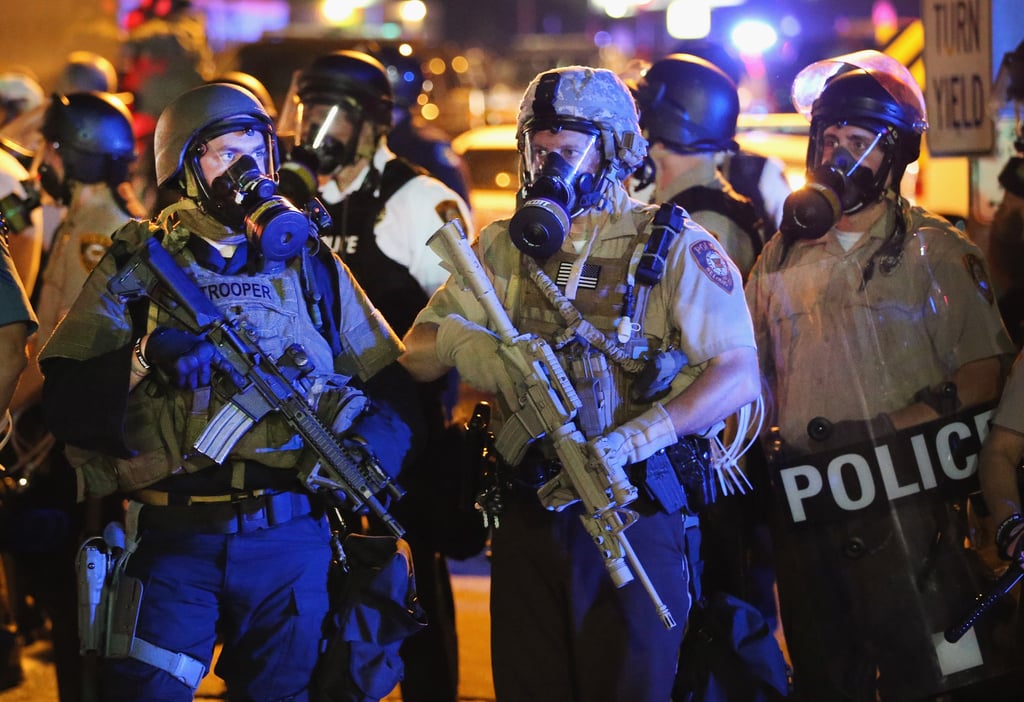 Police in combat gear and gas masks stood in the streets. Police in combat gear and gas masks stood in the streets.