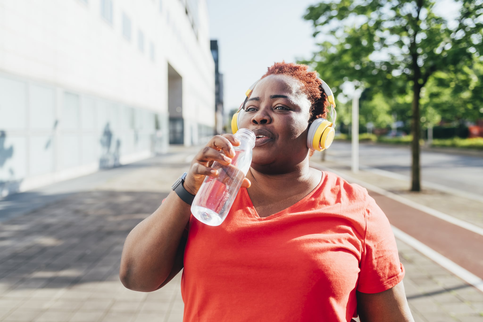 Woman drinking water while going for a walk outside